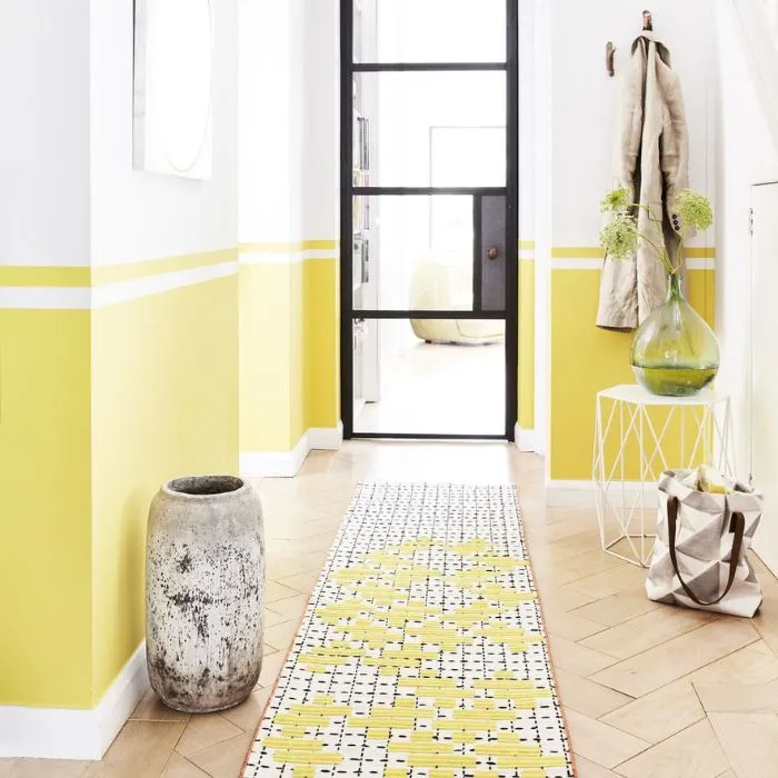 Bright yellow hallway with matching rug, featuring wood tiles