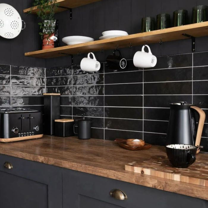 Contemporary kitchen design with black metro tiles and wooden counters