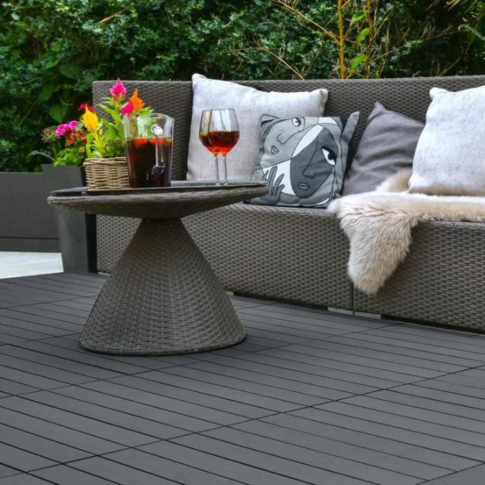 Grey outdoor sofa scene with wine glass, set against sleek deck tiling