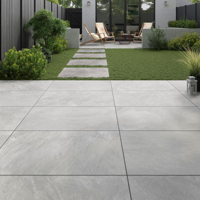 Serene grey tiled patio in a calm backyard setting