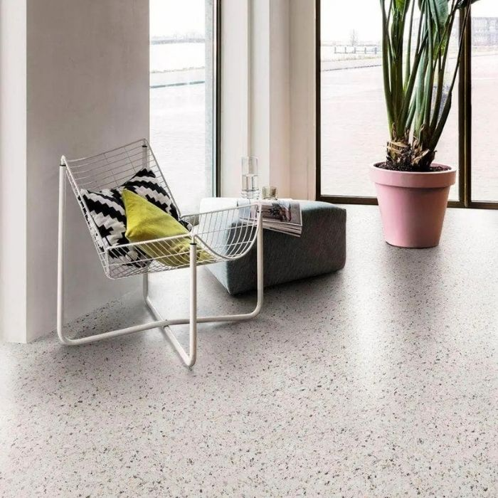 Inviting living room scene showcasing a chair complemented by a bright potted plant, resting on beautiful vinyl flooring 