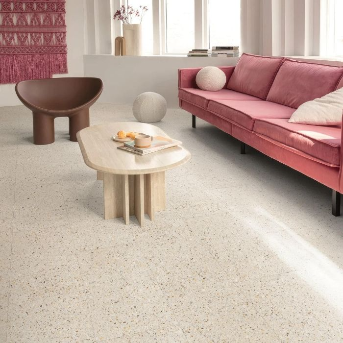 Living room with white terrazzo floor tiles, pink sofa, and minimalist furniture