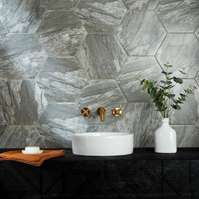 A chic bathroom with a visually striking hexagon tile wall and a sleek sink