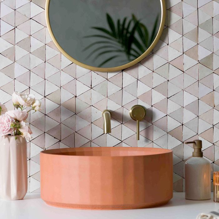 Bathroom sink with rose pink and white triangle zellige tiles