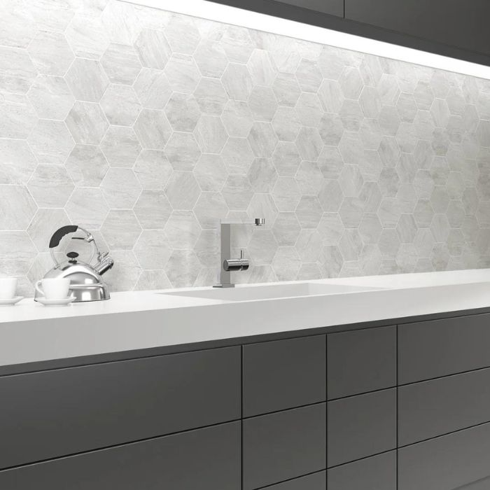 A stylish white and black kitchen featuring a striking hexagon white tile backsplash