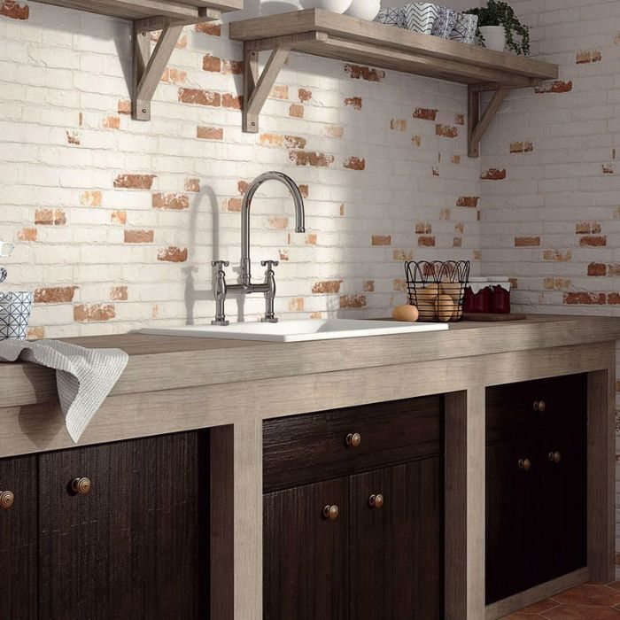 A bright kitchen featuring a white sink and wooden cabinets against a stylish brick-effect wall