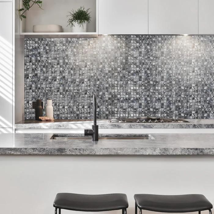 Monochrome kitchen interior with striking anthracite mosaic backsplash.