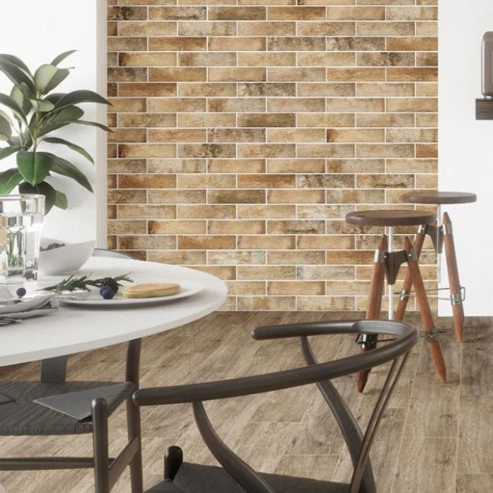 A cosy dining room featuring a wooden table and chairs, complemented by stylish brick-effect wall tiles