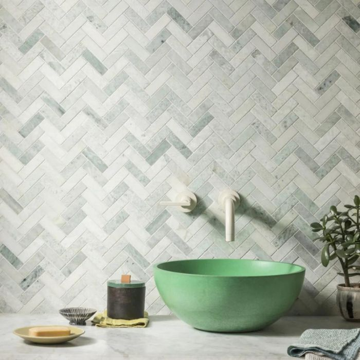 Minimalist bathroom with textured green herringbone tiles