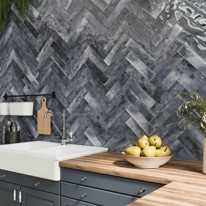 A stylish kitchen featuring a black and grey herringbone tile wall that adds elegance and texture