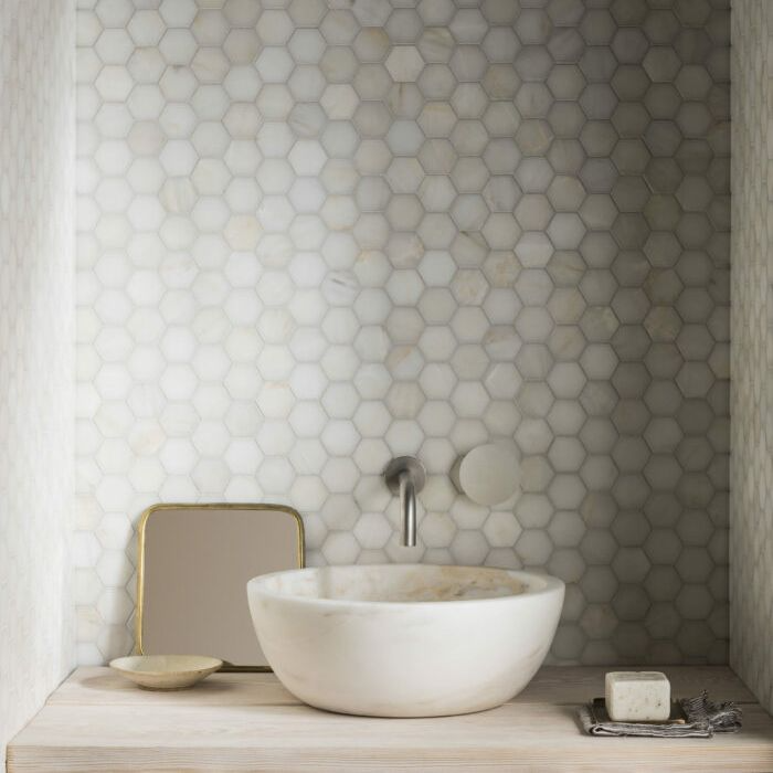 Stylish bathroom sink and mirror against monochrome hexagonal tiles