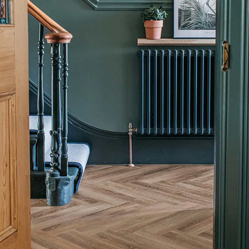 A hallway with green walls and wooden floor tiles