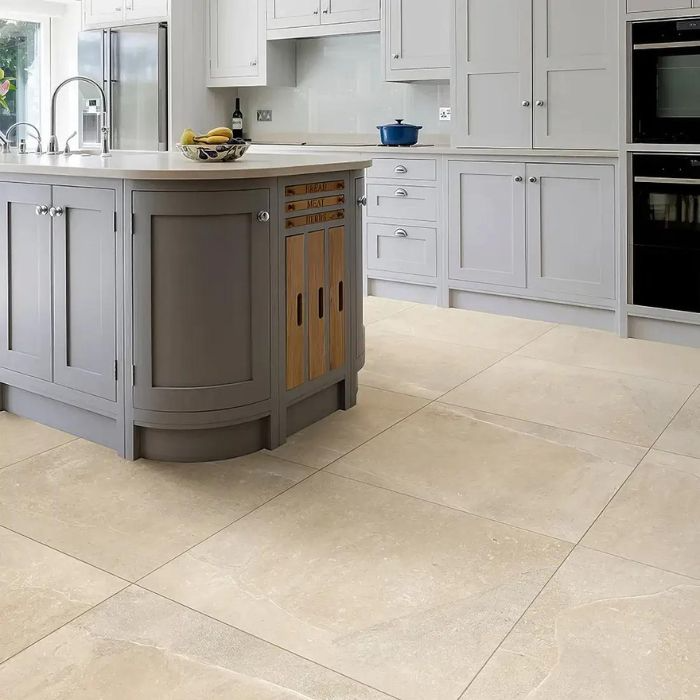 Beige porcelain floor tiles complement white kitchen cabinets