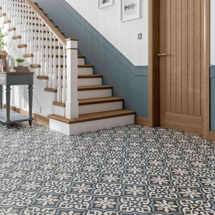 Tiled floor pattern in shades of blue and white with staircase