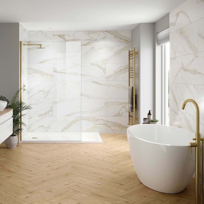 White and gold tones dominate this chic bathroom, complete with pristine marble flooring and a freestanding tub