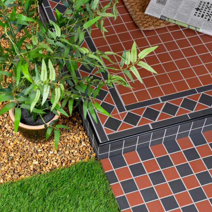 Stylish black and red tiled porch adorned with a lively potted plant