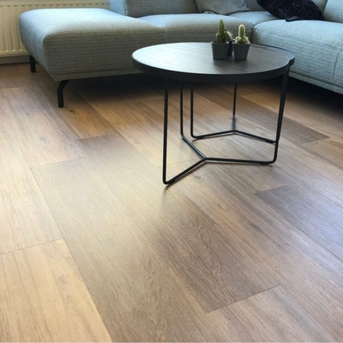 A living room scene showcasing a grey sofa and table on sleek vinyl flooring 