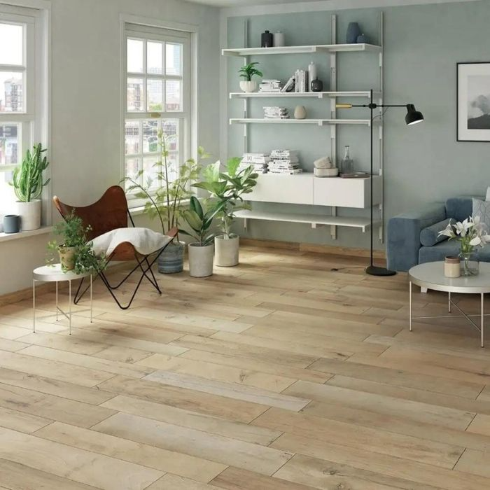 A bright living room featuring blue green walls and polished wooden floors