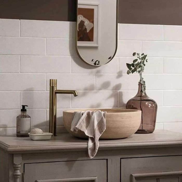 Elegant white sink and mirror in a bathroom, complemented by contemporary brick-effect wall tiles