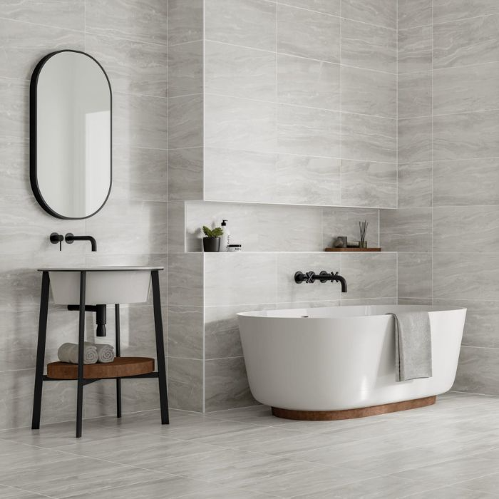 Stylish monochrome bathroom with bathtub, sink, and mirror, complemented by intricate marble tiles