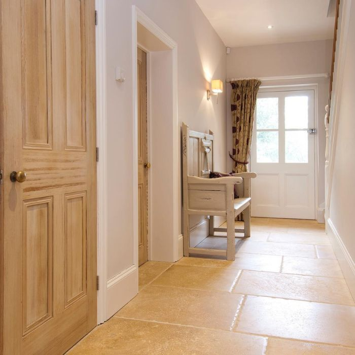 A serene hallway with wooden doors, a bench, and stylish floor tiles