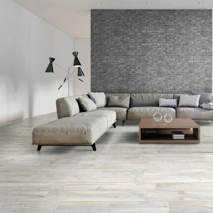 A chic modern living room featuring a striking brick wall accent and white wood-effect tiles