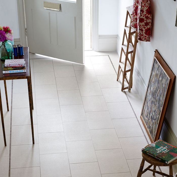 Serene white-tiled hallway showcasing a door and a minimalist table against the wall