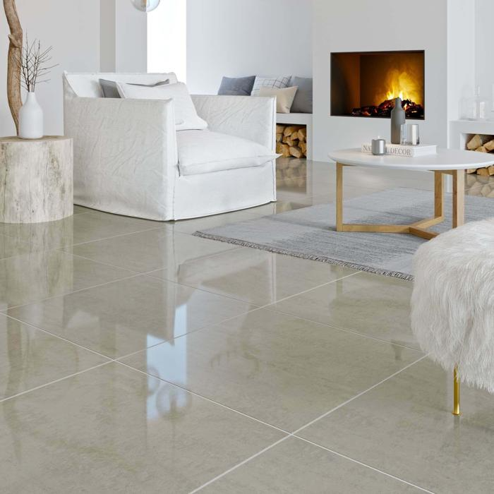 Serene lounge area showcasing white furniture, a fireplace, and a beautiful porcelain floor that adds warmth