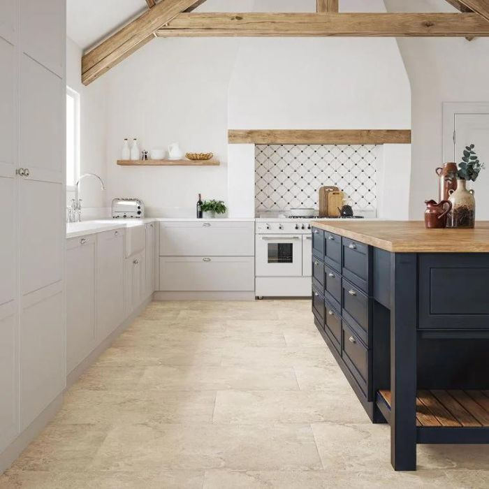 Inviting kitchen space with wooden beams, white cabinets, and antique-effect floor tiles