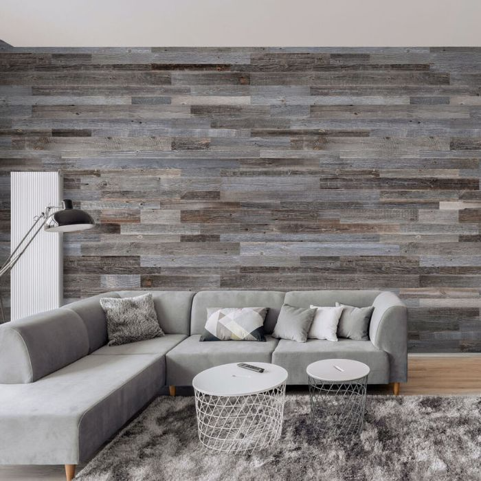 Stylish interior featuring a grey couch set against a rustic wood-effect wall