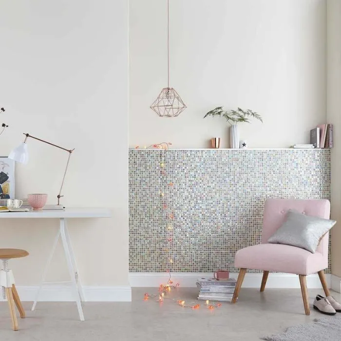 Soft pink hues in a room with a chair and mosaic wall