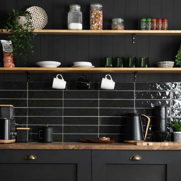 Stylish black kitchen with wooden shelves and pots and pans