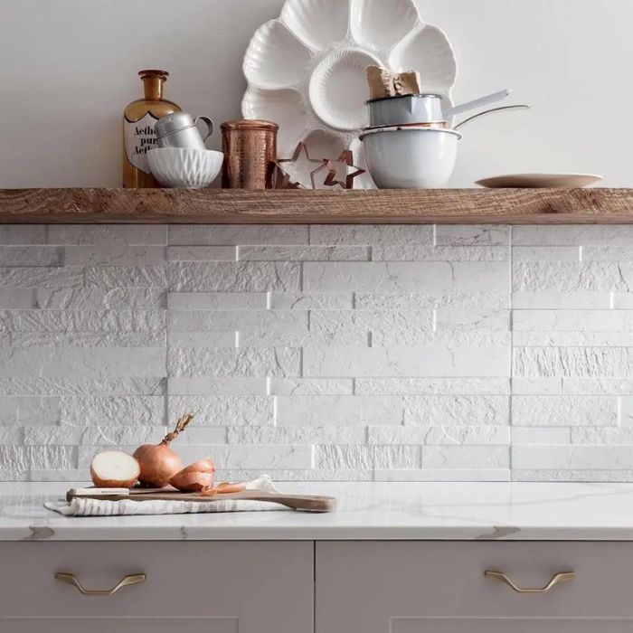 A stylish kitchen featuring a sleek white tile backsplash and rustic wooden shelves