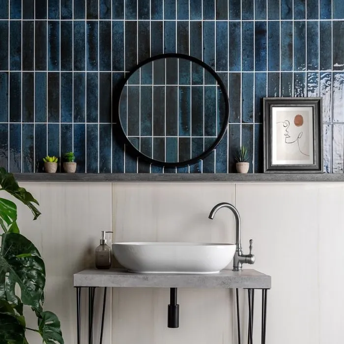 Blue tiled bathroom with sleek sink and mirror