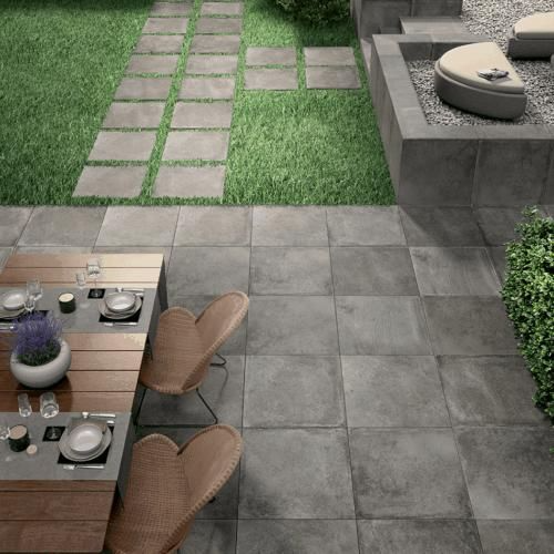 Trendy patio design featuring chic table and chairs on grey outdoor tiles