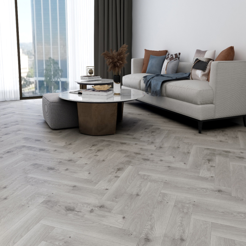 Neutral-toned living space featuring white furniture & trendy herringbone floor design