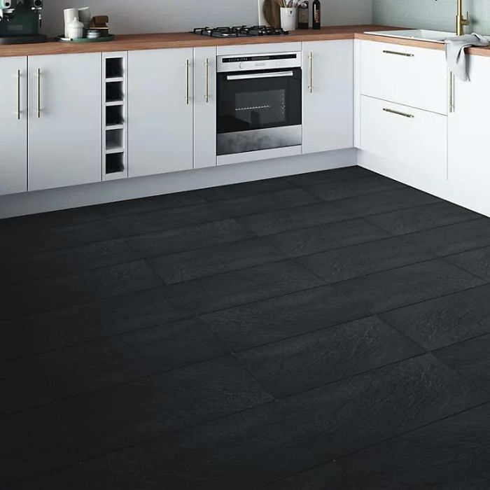 Minimalist kitchen with black tile floor and white cabinets