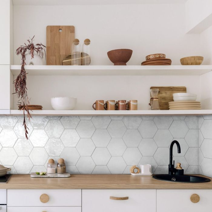 A modern white kitchen featuring a sleek white tile backsplash that reflects light beautifully