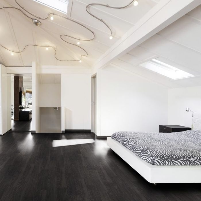 Contemporary bedroom with sleek black hardwood flooring and a wall-mounted television 