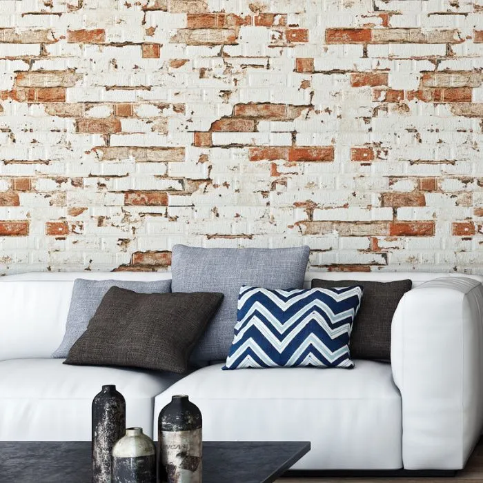 White couch in front of brick wall in bright living room