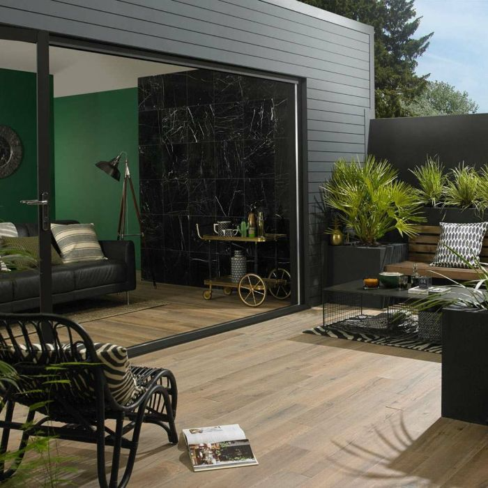 Stylish black furniture contrasting with lush green plants in a mdoern patio