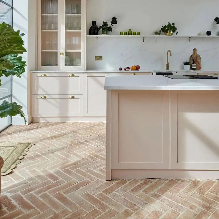 Pink-hued terracotta parquet tiles in a kitchen