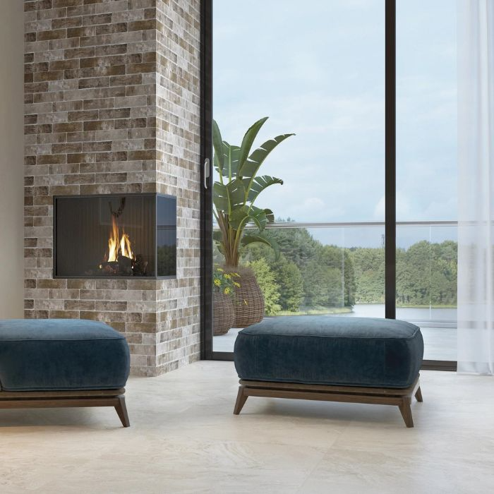 Two blue ottomans placed in front of a brick fireplace with bricke-effect fireplace tile ideas