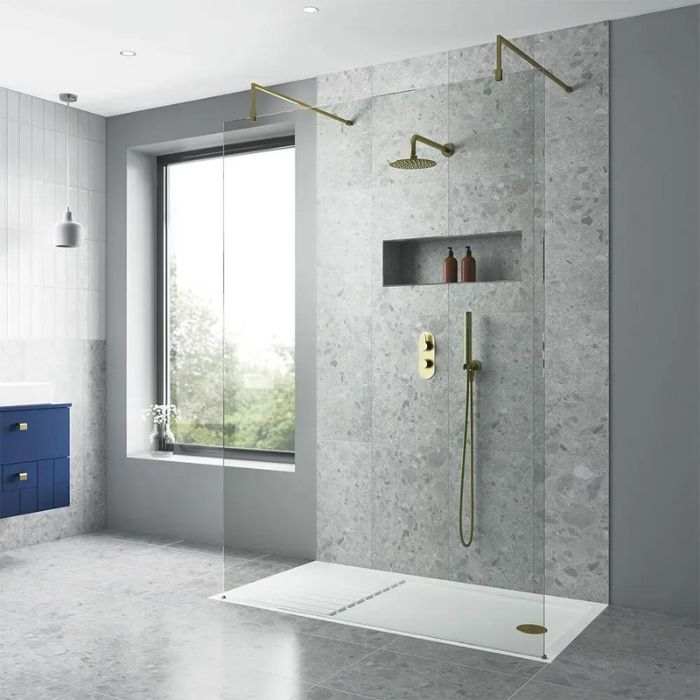 Glass shower enclosure in a trendy bathroom with textured and classy grey tile work