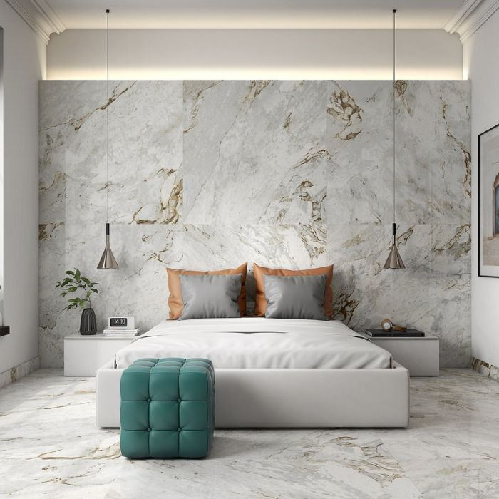 A luxurious bedroom featuring stunning marble walls and a pristine white bed