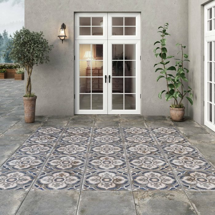 A patio with patterned floor tiles leading to a closed white door