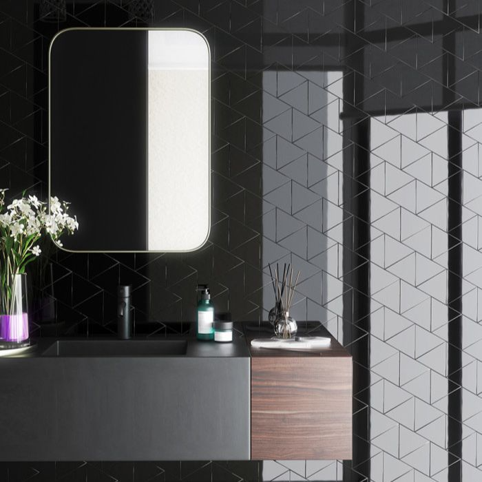 Stylish monochrome bathroom with black tiles and mirror