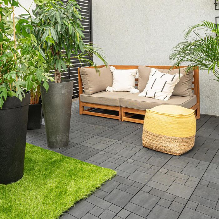 Outdoor patio featuring a comfy couch with colourful potted plants