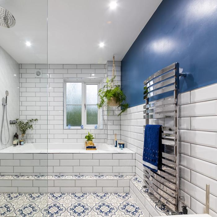 White subway tiles and blue wall with patterned floor tiles