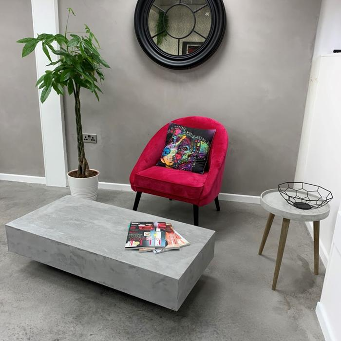 Minimalist room with concrete floor and red chair